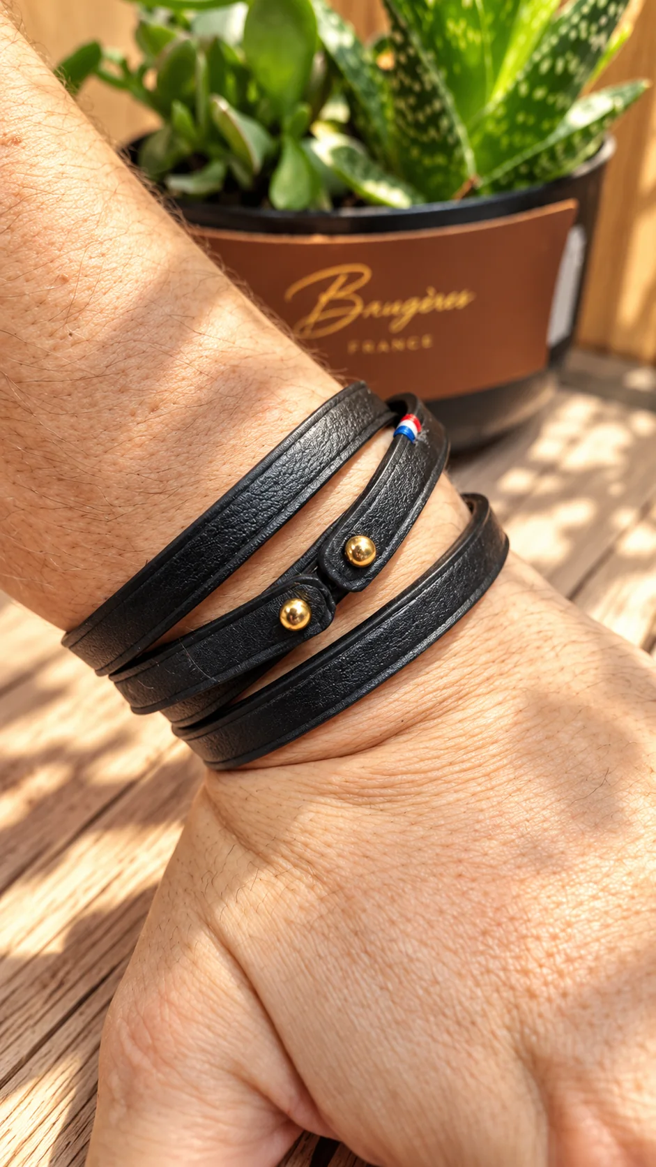 Bracelet noir en cuir porté au poignet