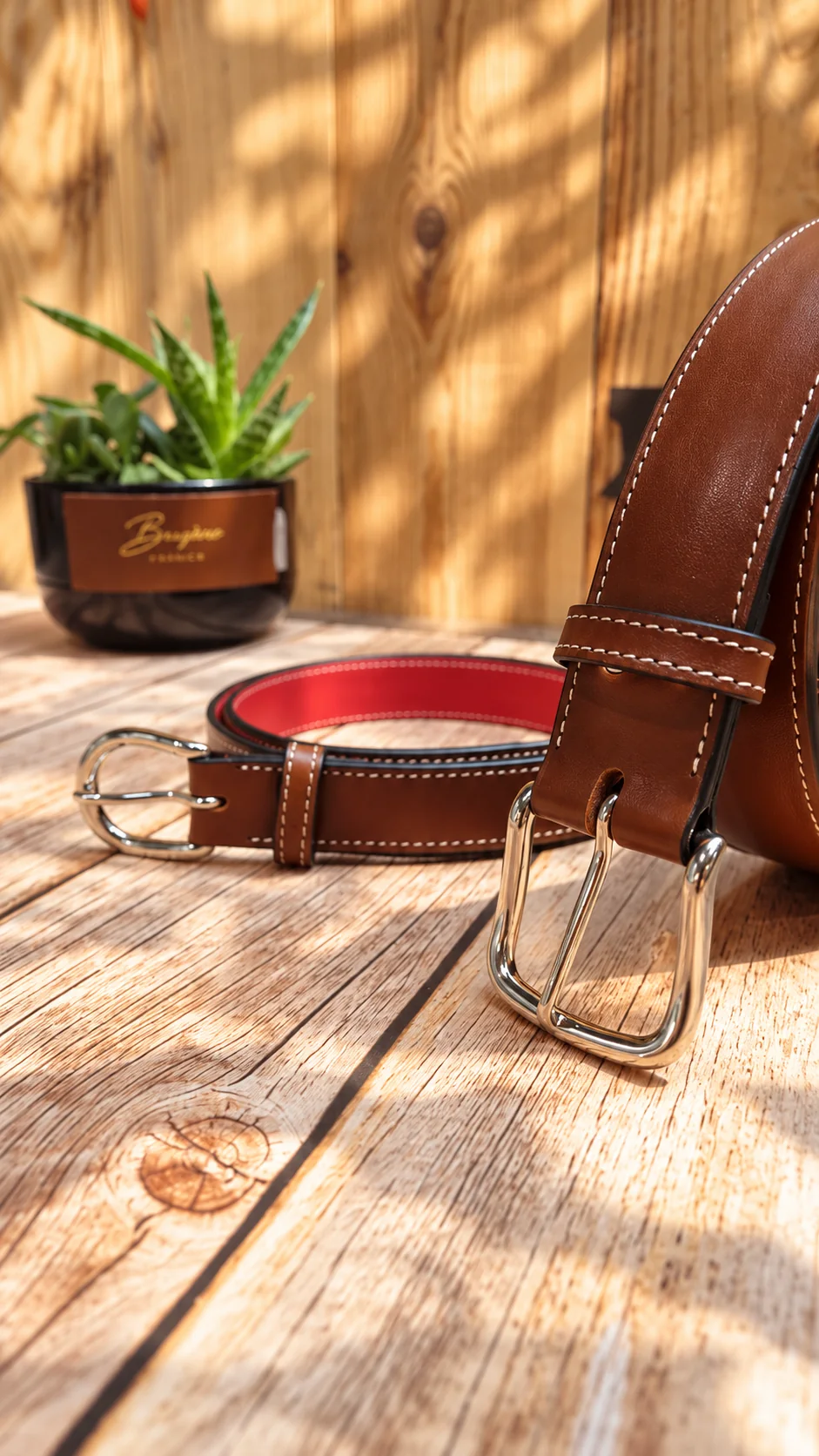 Ceintures en cuir et boucles posées sur un établi ensoleillé