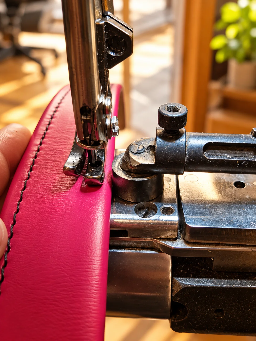 Une machine à coudre assemble un cuir rose